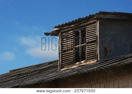 Wooden Extension On An Old Brick Building. Against The Blue Sky