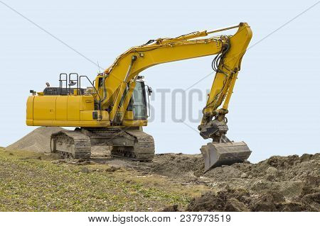 Yellow Excavator At A Loamy Construction Site, Partly Isolated In Light Blue Back