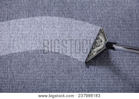 Close-up Of A Vacuum Cleaner Over Grey Carpet