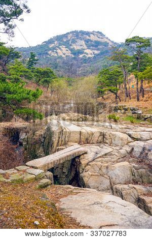 View of Inwangsan Mountain, a rocky stream with a bridge, pine grove.