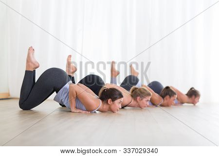 Group Of Young Sporty Sexy Women In Yoga Studio, Practicing Yoga Lesson With Instructor, Forming A L