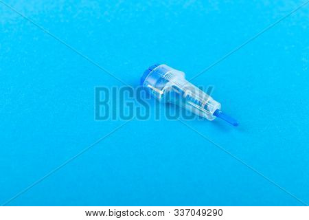 Childrens Scarifier For Taking Blood. The Device In The Blood Sample Of The Child. On A Blue Backgro