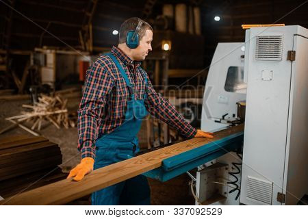 Woodworker works on machine, lumber industry