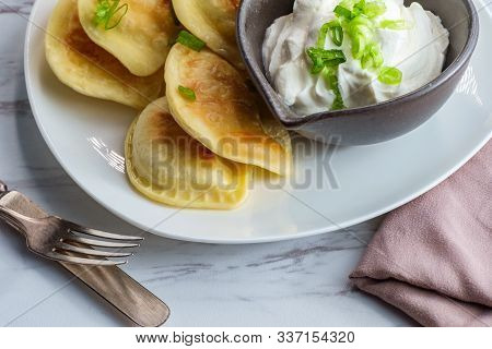 Delicious Authentic Polish Pierogies With Chopped Green Onion And Sour Cream