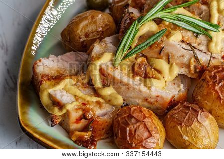 Sliced Honey Mustard Roast Pork Tenderloin With Baby Potatoes And Caperberry Garnish