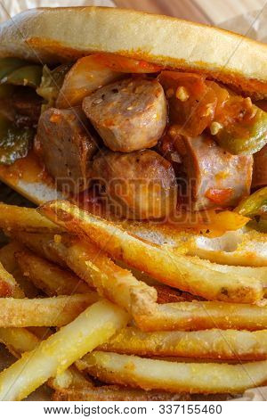 Fried Sausage Onions And Red Green And Yellow Bell Peppers On Sandwich Bun