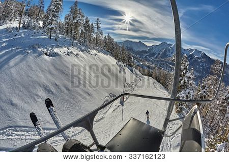 Skiing slope in the Alps with snowy trees in Les Arres, France from sitting on a ski lift