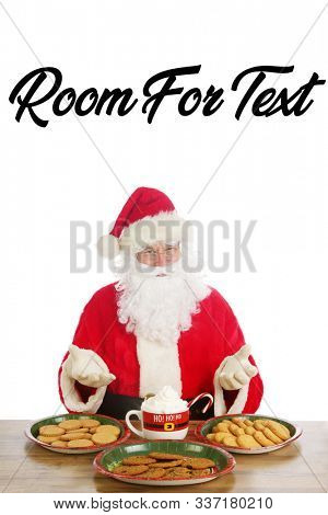 Santa Claus. Christmas Santa. Isolated on white. Room for text. Santa Claus holds a cup of Hot Coco with a Candy Cane and Whip Cream. Santa Loves Hot Coco and Cookies on Christmas. 