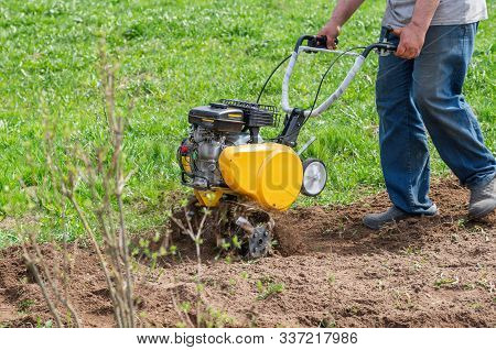 Cultivator For Tillage In The Garden,motor Cultivator. Man Farmer Plows The Land With A Cultivator.