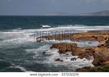 Wild Waves Of The Mediterranean Sea With A White Foam. Sunny Spring Day With White Clouds On The Blu