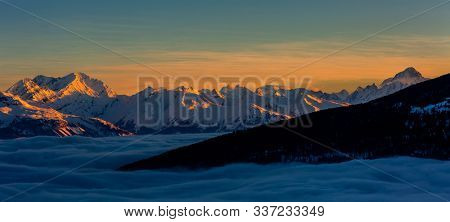 Scenic panorama sunset landscape of Crans-Montana range in Swiss Alps mountains with peak in background, Crans Montana, Switzerland.