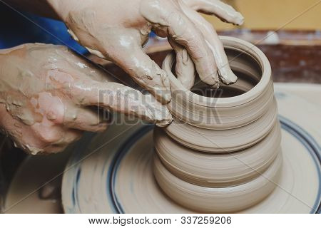 Woman Hands On Pottery Wheel, Potter At Work. Craftsman Artist Shapes Pot