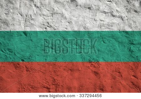 Bulgaria Flag Depicted In Bright Paint Colors On Old Relief Plastering Wall. Textured Banner On Roug