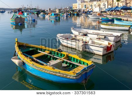 Multi-colored Luzzu Fishing Boats In The Harbor. Marsaxlock Sunny Morning. Malta.