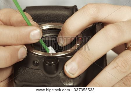 Spacialist Technician Cleaning Digital Camera Sensor With Stick