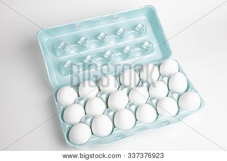 A Close-up Shot Of A Bright Green Styrofoam Crate Full Of White Eggs Set On A White Background.