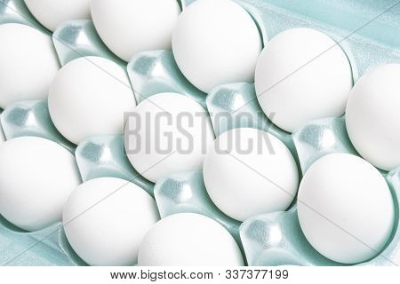 A Close-up Shot Of A Bright Green Styrofoam Crate Full Of White Eggs Set On A White Background.