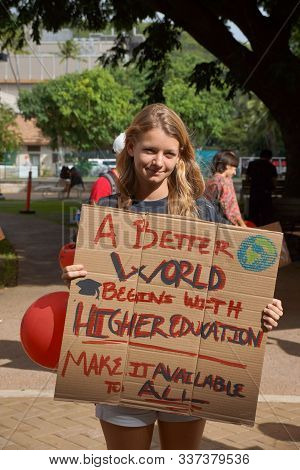 Honolulu - November 12, 2015:  Lady Holds Sign Saying A Better World Begins With Higher Education Ma