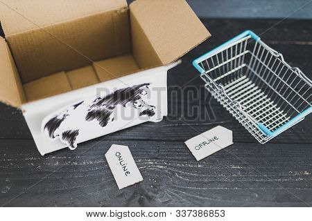 Online Vs Retail Shopping Conceptual Still-life, Parcel With World Map And Shopping Basket With Onli