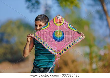 Cute Indian Child Playing With Kite In Farm