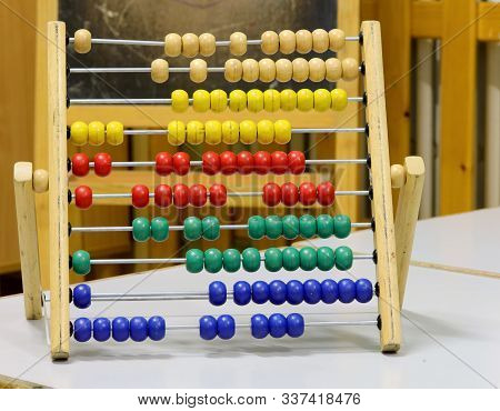 Wooden Abacus With Many Small Beads In The Classroom