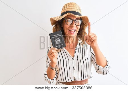 Senior tourist woman holding Italy Italian passport standing over isolated white background surprised with an idea or question pointing finger with happy face, number one