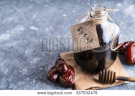 Homemade Dates Syrup In Glass Bottle On Gray Stone Table. Alternative Food And Drink Trend Food 2020