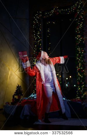 Bad Santa Claus Lonely At Christmas. Aggressive Man In A Suit Of Santa Claus On The Background Of Ne