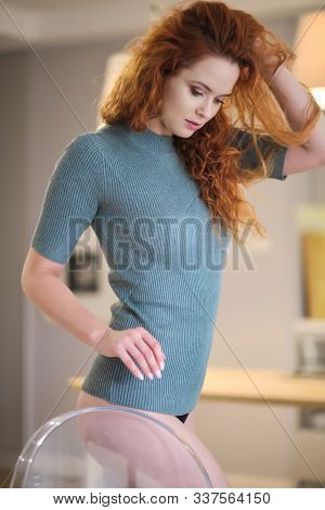 Gorgeous young redhead woman with long coppery hair and blue eyes looking at the camera, close up head shot with copy space