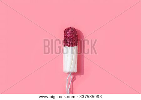 Tampon With Red Glitter Instead Of Blood On Pink Background.