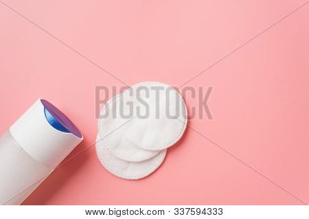Micellar Water With Cotton Pads On A Pastel Pink Background. The Concept Of Cleansing And Moisturizi