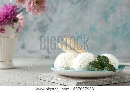 Homemade Vanilla Ice Cream Scoops In Waffle Cone  In Blue Ice-cream Bowl With Berry Spoon In Modern 