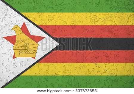 Zimbabwe Flag Depicted In Bright Paint Colors On Old Relief Plastering Wall. Textured Banner On Roug