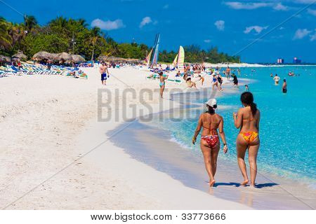 VARADERO, CUBA-maj 27:Two piger at gå og turister nyder stranden kan 27,2012 i Varadero.With 
