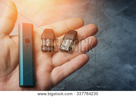 Vape Pod System Or Pod Mod With Changeable Cartridges Close Up In Male Hand.