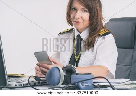 Beautiful woman pilot wearing uniform with epaulettes doing preflight briefing