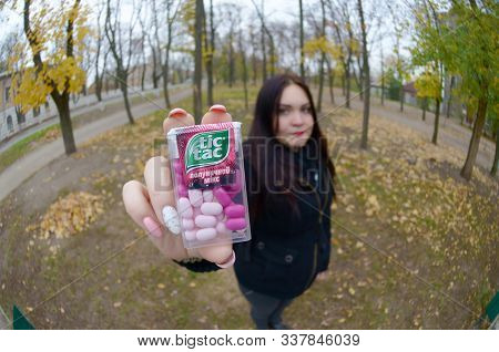 Kharkov, Ukraine - October 26, 2019: Young Woman Shows New Tic Tac Hard Mints Package In Autumn Park