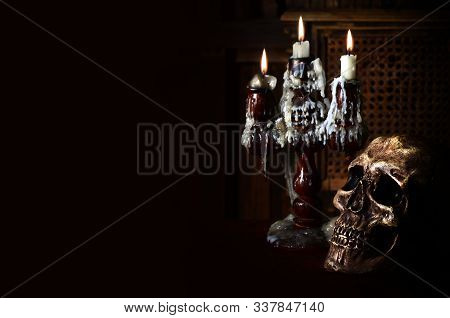 Old Battered Skull Lies With An Antique Wooden Candlestick