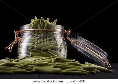Jar Of Foglie Spinach Pasta On Wooden Table Isolated On Black Background