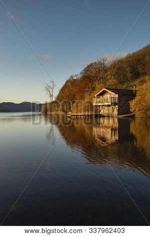 Stunning Sunrise Autumn Fall Landscape Image Of Ullswater In Lake District With Golden Sunlight