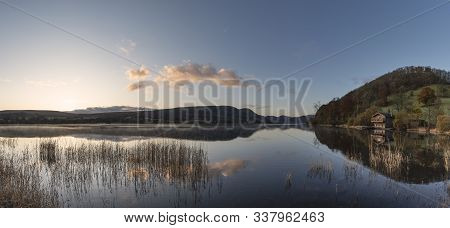 Stunning Sunrise Autumn Fall Landscape Image Of Ullswater In Lake District With Golden Sunlight