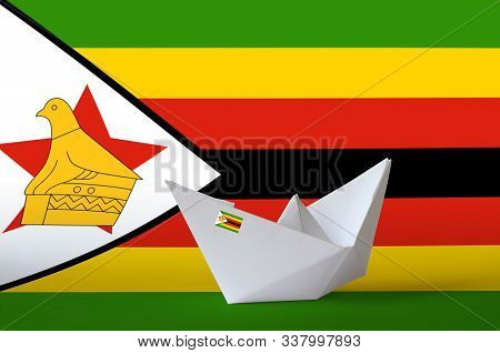 Zimbabwe Flag Depicted On Paper Origami Ship Closeup. Handmade Arts Concept