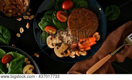 Soy Protein Burger On Brown Rice With Spinach, Tomato, Champion, Carrot And Nuts On A Plate.