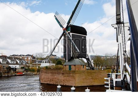 Cityscape Of Leiden, The Netherlands. View Of New Rhine River And Dutch Houses And Traditional Windm