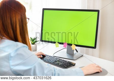 Close Up Of Female Hands And Pc With Green Chromakey Blank Screen. Mock-up Of Computer Monitor.