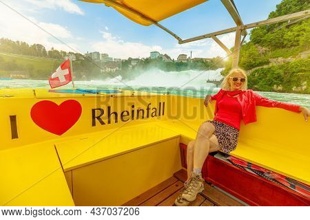 Woman By The Boat On The Swiss Waterfall Rheinfall In Switzerland At Sunset. 490 Ft Wide And 75 Ft H