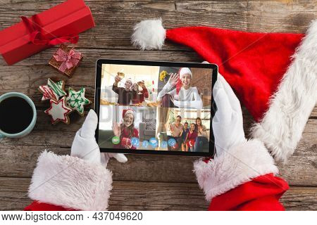 Santa claus on christmas laptop video call with diverse group of friends. christmas, festivity and communication technology.