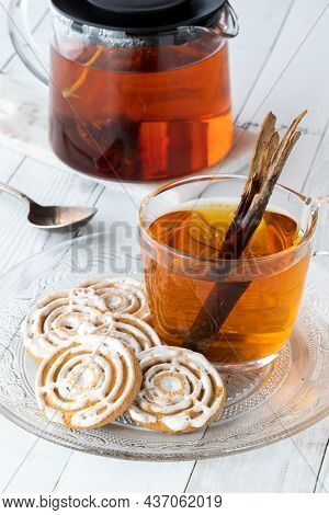 A Glass Plate Of Cinnamon Swirl Cookies Served With Cinnamon Chia Tea.