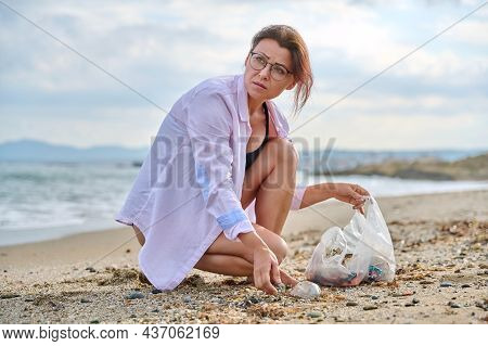 Active Woman Tourist Relaxing On The Beach Collecting Plastic Trash In A Bag