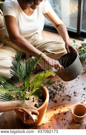Woman repotting plants in the new normal